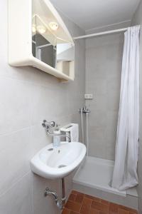 a white bathroom with a sink and a shower at Apartments with a parking space Kornic, Krk - 415 in Kornić