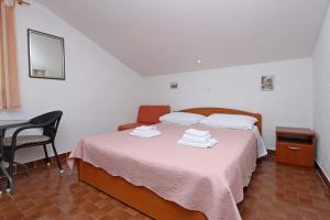 a bedroom with a bed with a table and a chair at Apartments with a parking space Kornic, Krk - 415 in Kornić