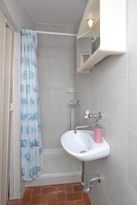 a bathroom with a sink and a shower curtain at Apartments with a parking space Kornic, Krk - 415 in Kornić