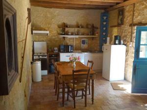 uma cozinha com uma mesa de madeira e um frigorífico branco em Gîte Fontenay-sur-Vègre, 3 pièces, 4 personnes - FR-1-410-275 em Fontenay-sur-Vègre