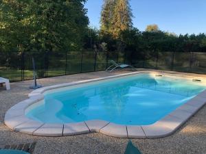 a swimming pool with blue water in a backyard at Gîte Dureil, 2 pièces, 4 personnes - FR-1-410-331 in Dureil