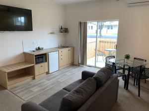 a living room with a couch and a table and a kitchen at Guichen Bay Motel in Robe