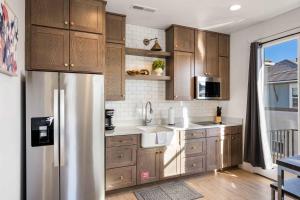 a kitchen with wooden cabinets and a stainless steel refrigerator at Casa De Luz Casita condo in St. George