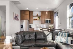 a living room with a leather couch and a kitchen at Casa De Luz Casita condo in St. George