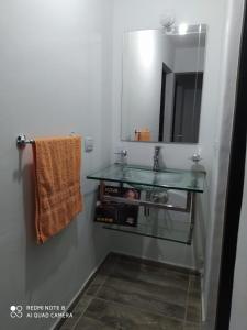 a bathroom with a glass sink and a mirror at Casa 3 dormitorios. - Barrio Valle Cercano in Córdoba +13 photos