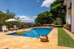 - une piscine dans l'arrière-cour d'une maison dans l'établissement Casa em Araras: Piscina, sauna e serviço incluído!, à Petrópolis