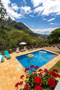uma piscina com vista para as montanhas em Casa em Araras: Piscina, sauna e serviço incluído! em Araras, Petrópolis