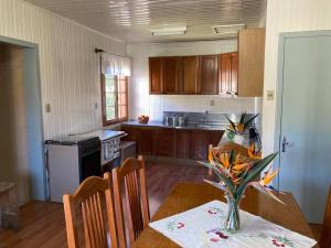 eine Küche mit einem Tisch und einer Blumenvase darauf in der Unterkunft Casa aconchegante no Vale Vinhedos in Bento Gonçalves