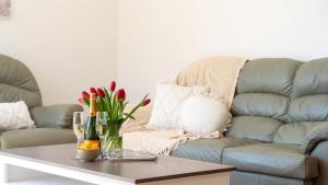a living room with a couch and a table with flowers at Salty Marlin in Callala Bay +25 photos