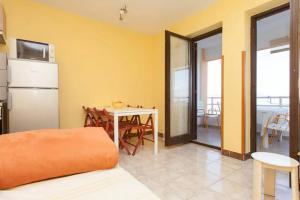 a kitchen with a table and a refrigerator and a table at Apartments with a parking space Ravni, Labin - 12891 in Ravni