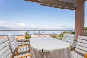 a table and chairs on a balcony with a view of the ocean at Apartments with a parking space Ravni, Labin - 12891 in Ravni