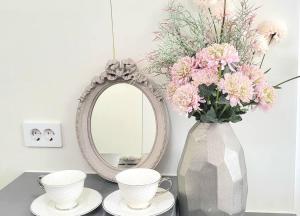 lustro i waza z kwiatami na stole w obiekcie Lavender House-IRUA w Pusanie