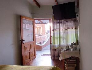 a room with a bed and a table and a door at Cómoda habitación con baño privado in Sucre