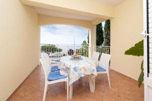 a dining room with a table and chairs on a balcony at Apartments by the sea Mandre, Pag - 4092 in Kolan