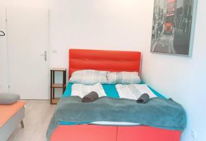 a bed with a red headboard in a room at Comfort Triple room HN in Vienna