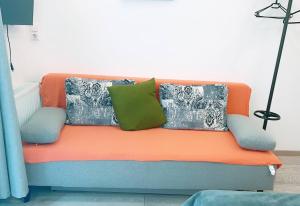 an orange couch with pillows on it in a room at Comfort Triple room HN in Vienna