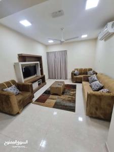 a living room with couches and a flat screen tv at Terhal salalah 1 in Salalah