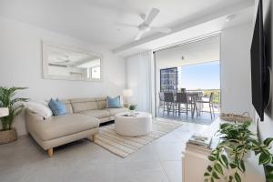 uma sala de estar com um sofá e uma mesa em Oceanus Bokarina Beach em Kawana Waters