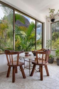 2 sillas y una mesa en una habitación con ventanas en Casa em Araras: Piscina, sauna e serviço incluído!, en Araras