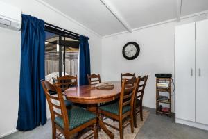tavolo da pranzo con sedie e orologio sul muro di Inverloch' s Lime Green Door - Linen, Wifi, Pet Friendly a Inverloch Altre 14 foto