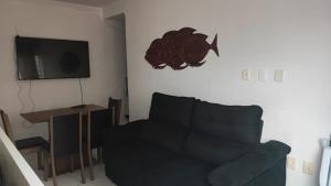 sala de estar con sofá y TV de pantalla plana en Ed Hang, en Porto Belo