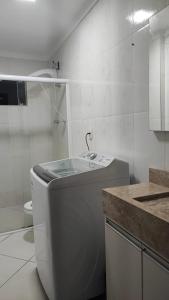 Baño blanco con aseo y lavamanos en Ed Hang, en Porto Belo