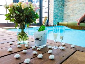 uma garrafa de champanhe e dois copos e flores numa mesa em Unique holiday home with starry sky pool em Culemborg