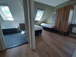a room with two beds and a bathroom with a tub at 20-person group home in the heart of Friesland in Leons