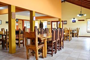 comedor con mesa de madera y sillas en Hosteria Quiñe en Caviahue