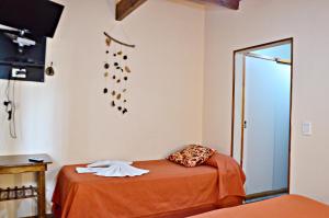 una habitación con una cama con zapatos colgando en la pared en Hosteria Quiñe en Caviahue
