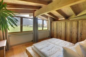 ein Schlafzimmer mit einem Bett und einem großen Fenster in der Unterkunft Appartements Coloman in Schwangau