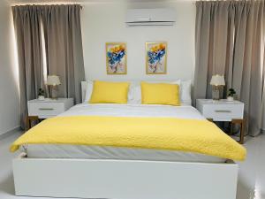 - une chambre avec un grand lit et des oreillers jaunes dans l'établissement Santiago Paradise Haven, à Santiago de los Caballeros
