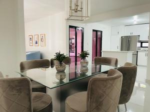 une salle à manger avec une table et des chaises en verre dans l'établissement Santiago Paradise Haven, à Santiago de los Caballeros