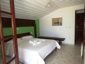 乌巴图巴Casarão Villa al Mare的卧室设有白色的床和绿色的墙壁
