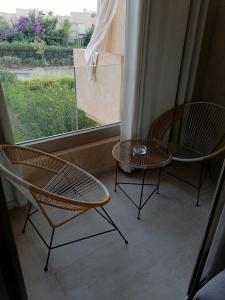 2 sillas y una mesa frente a una ventana en Marrakech, en Marrakech