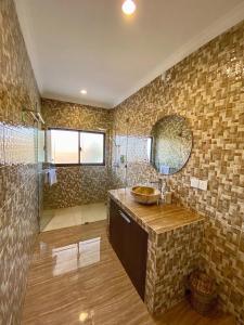 a bathroom with a sink and a glass shower at The Hamsa in Lovina