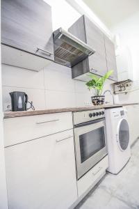 a kitchen with white appliances and a plant on the counter at Modern Double room HN in Vienna