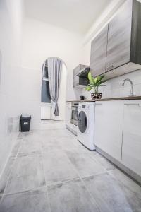 a white kitchen with a washer and dryer in it at Modern Double room HN in Vienna