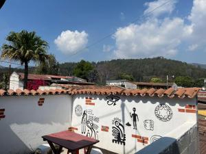 een witte muur met tekeningen erop met een tafel erop bij Hotel Cristal in Antigua Guatemala