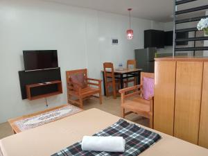 Pokój ze stołem i krzesłami oraz telewizorem w obiekcie Maria Cristesa Condotel 
