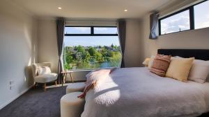 a bedroom with a bed and a large window at Experience The Magic of Riverside Living - 5 beds in Hamilton