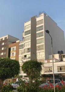 ein hohes Gebäude mit davor geparkt in der Unterkunft Edificio parque residencial in Lima