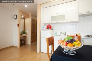 a bowl of fruit on a table in a kitchen at Gyeongju Ilsung Condo in Gyeongju