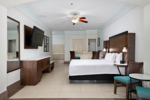 a hotel room with a bed and a television at Sand Rose Beach Resort in South Padre Island