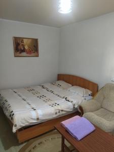 a bedroom with a bed and a couch and a chair at Космос in Bishkek