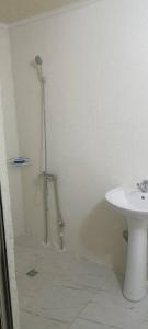 uma casa de banho branca com um lavatório e um WC em Космос em Bishkek