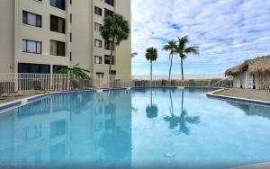 a large blue swimming pool in front of a building at Always Summer On a White Sandy Beach in Fort Myers Beach