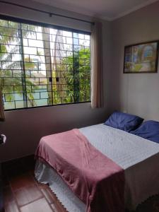 sypialnia z łóżkiem i dużym oknem w obiekcie Pousada Cantinho D´Lilica w mieście Balneário Praia do Leste