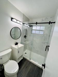 y baño blanco con ducha y aseo. en Stylish 3/2 centrally located!, en Miami