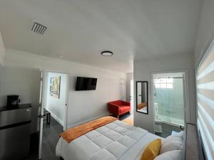 1 dormitorio con 1 cama blanca y 1 silla roja en Stylish 3/2 centrally located!, en Miami